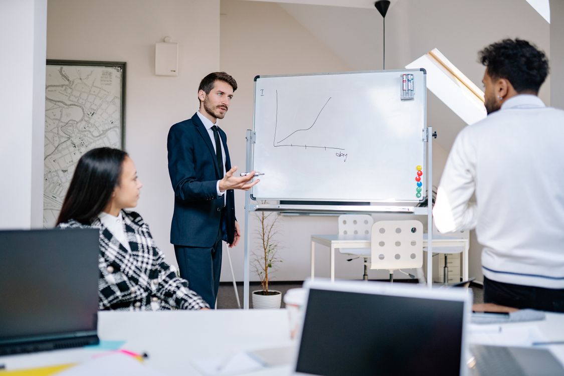 Business team reviewing a growth chart on a whiteboard